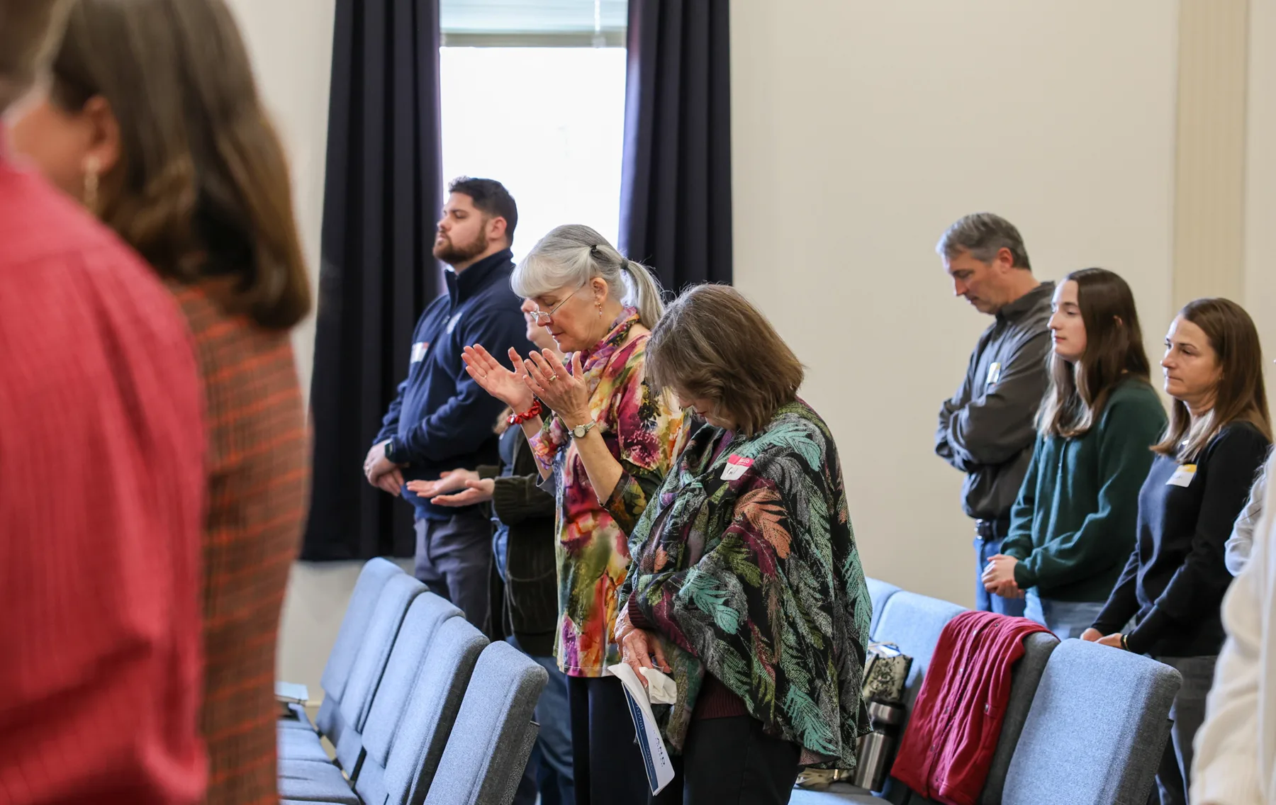 Members greeting one another before Sunday worship